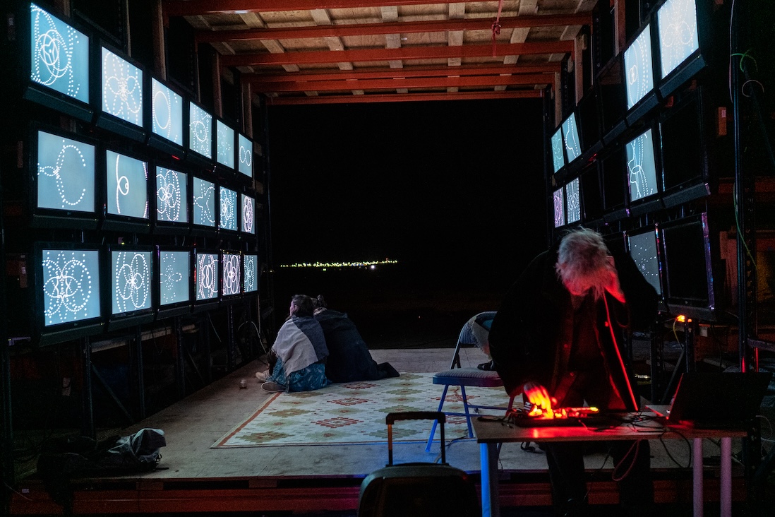 An art installation with a wall of CRT monitors displaying generative art.