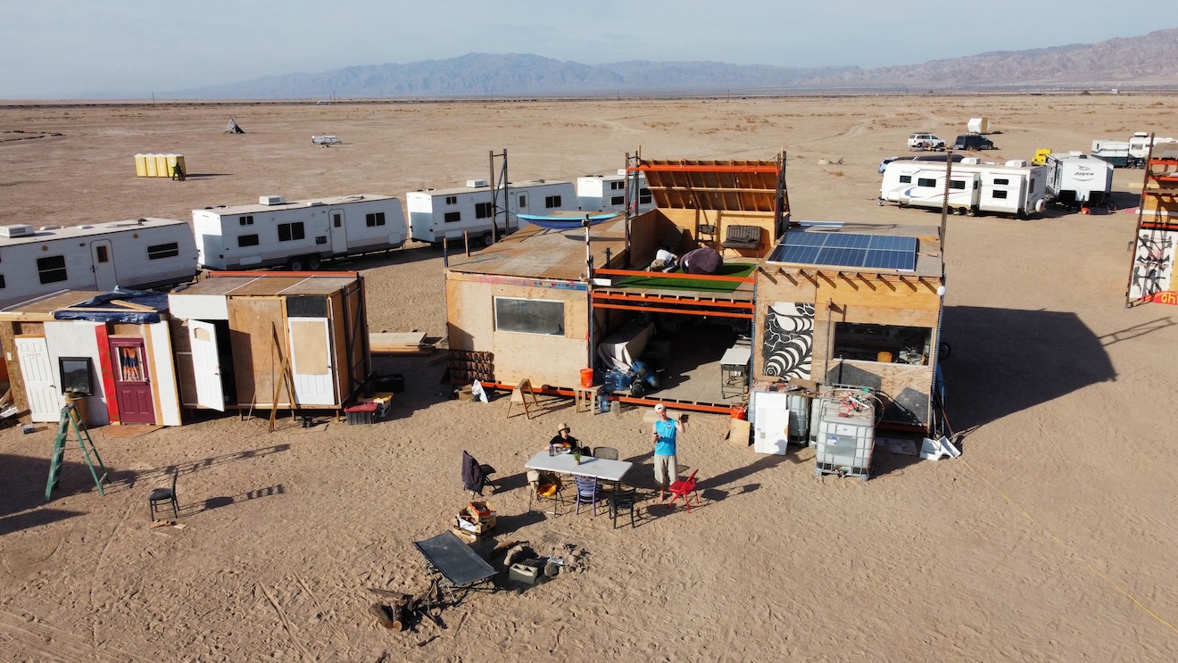 An aerial view of the Mars College settlement with RVs and custom structures.