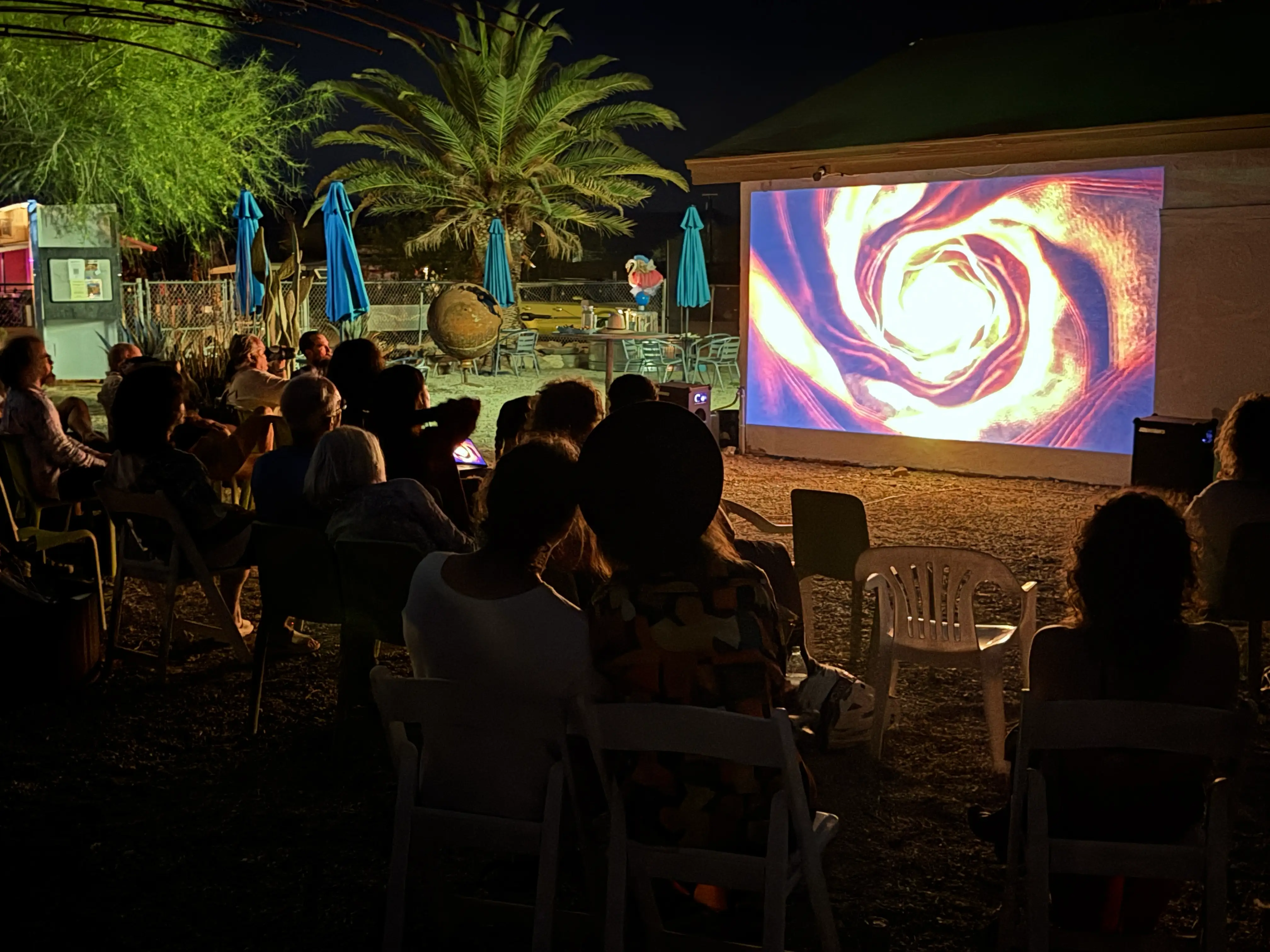 Abstract generative film projected under the desert sky · 2026