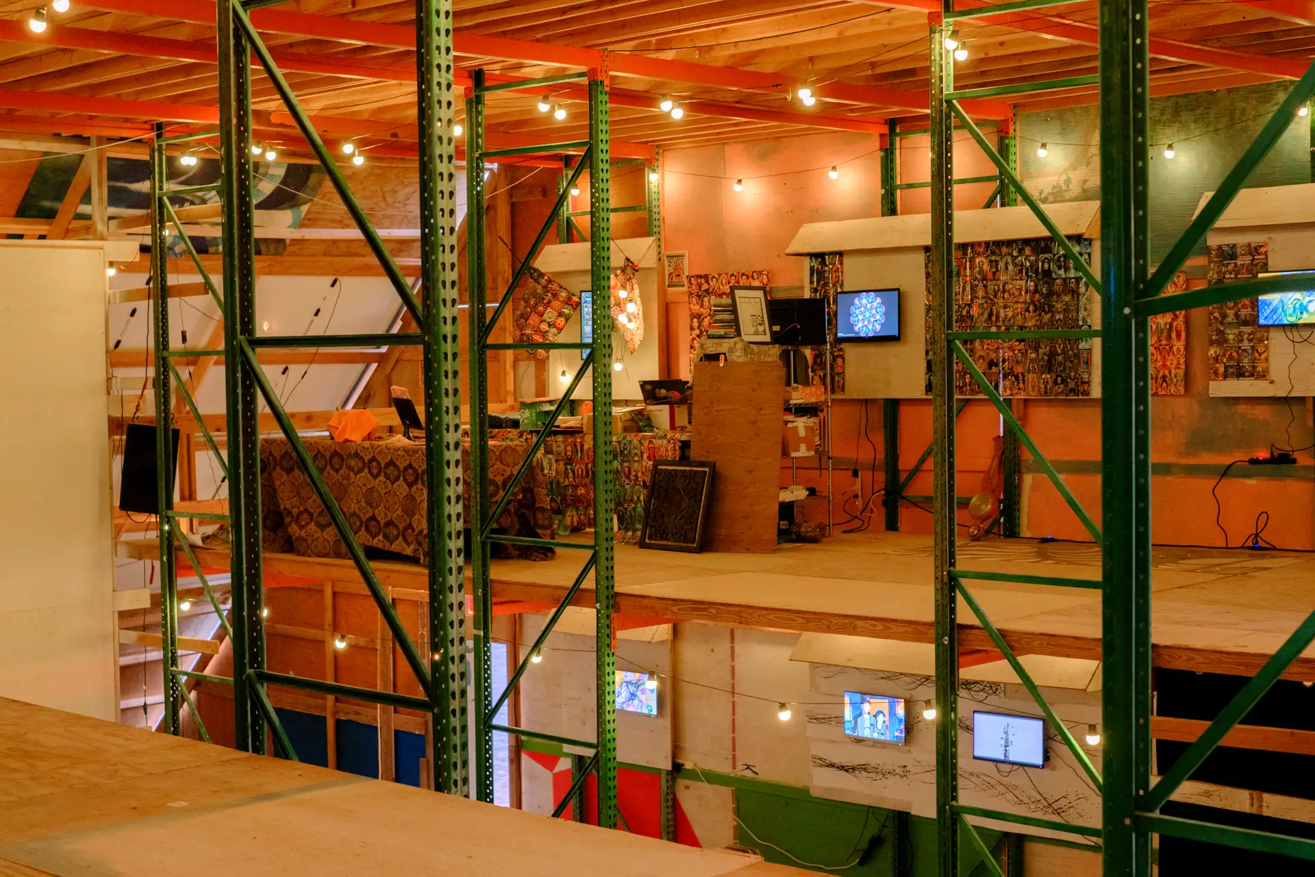 The AI gallery inside the Chiba hangar — screens mounted on pallet racks · 2026