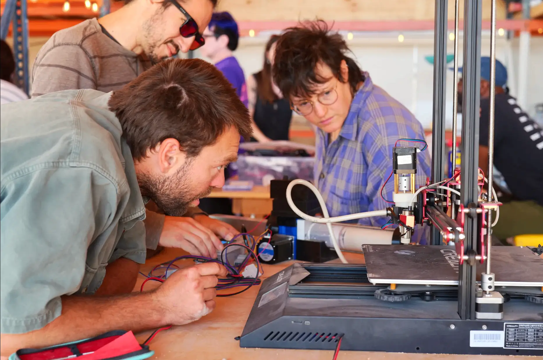 Two residents tinkering with a 3D printer in the workshop