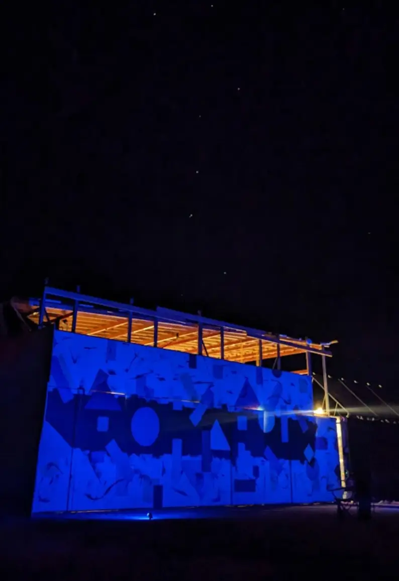The workshop lit blue against the night sky