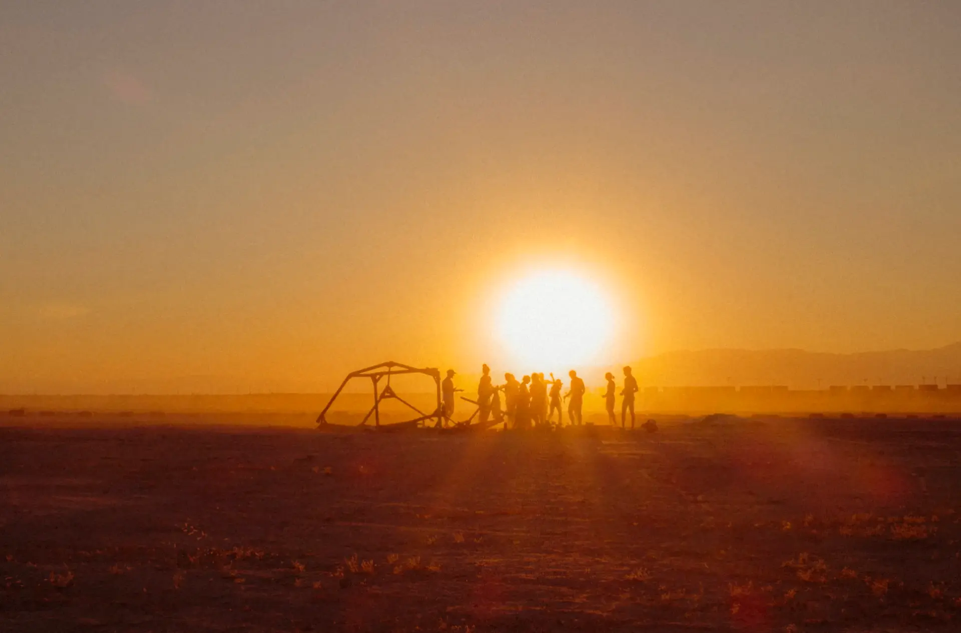 The camp silhouetted together against a desert sunset