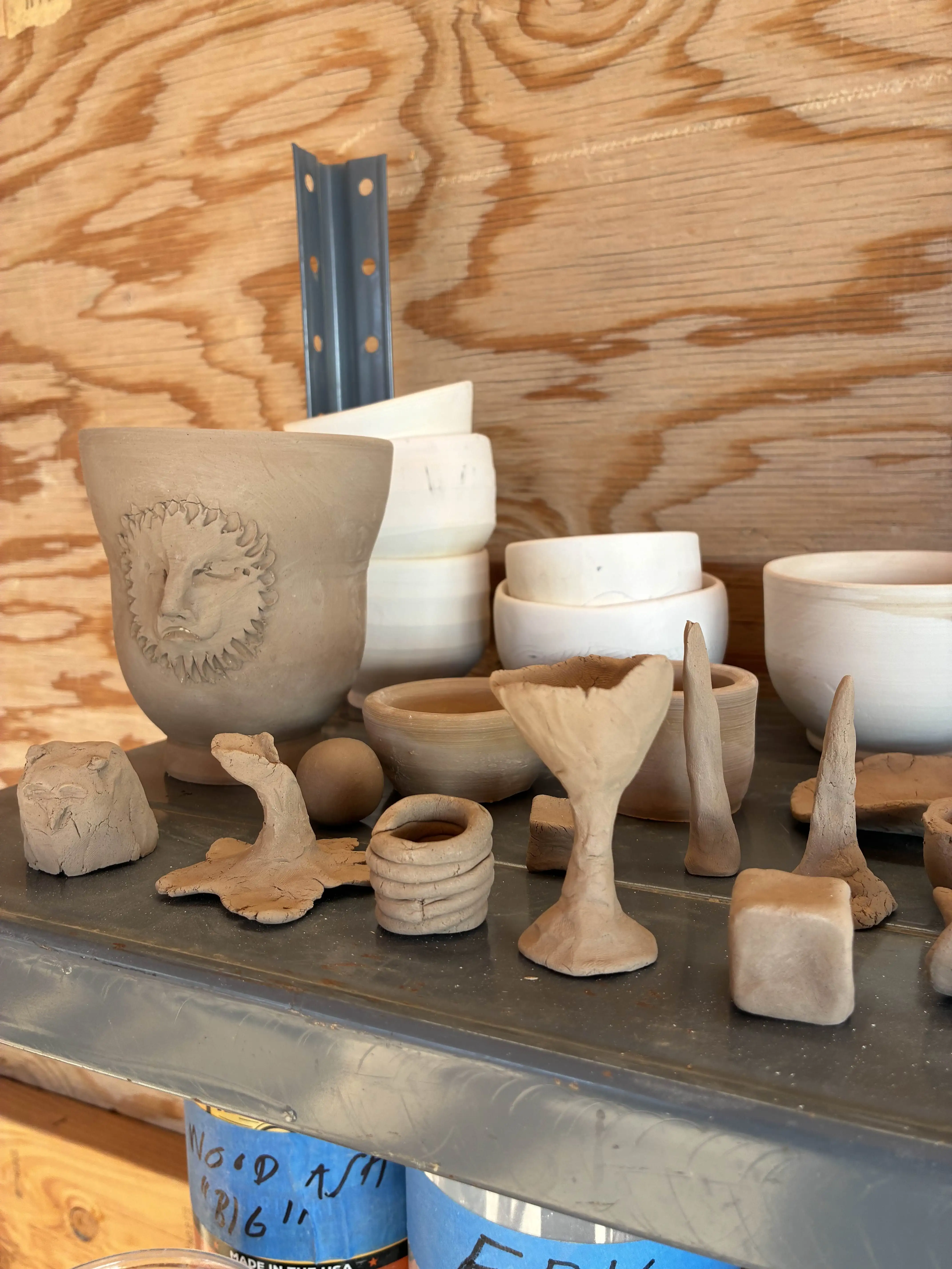 Workshop shelf of unfired clay · 2026