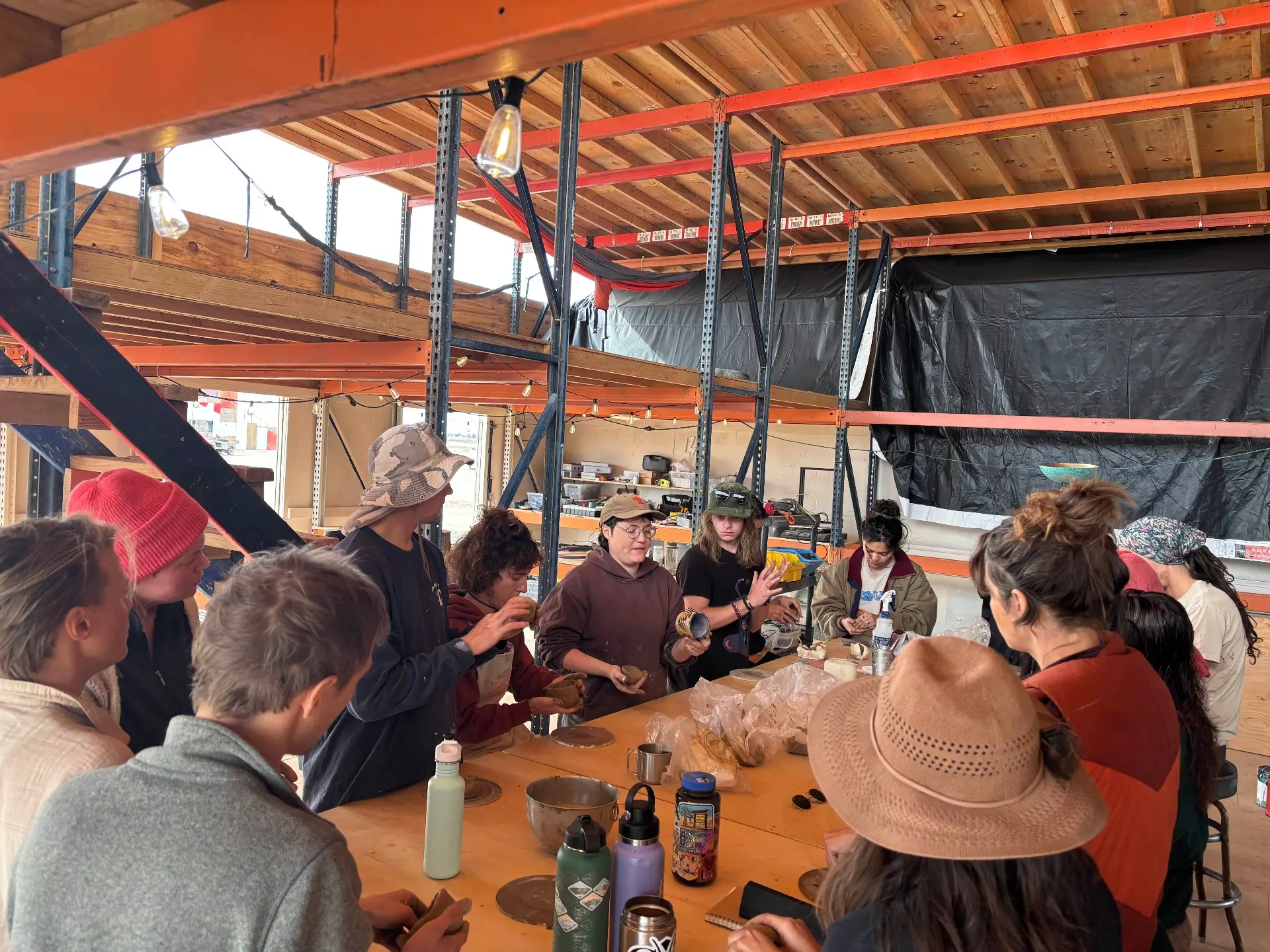 Residents gathered around a workshop table, shaping clay together