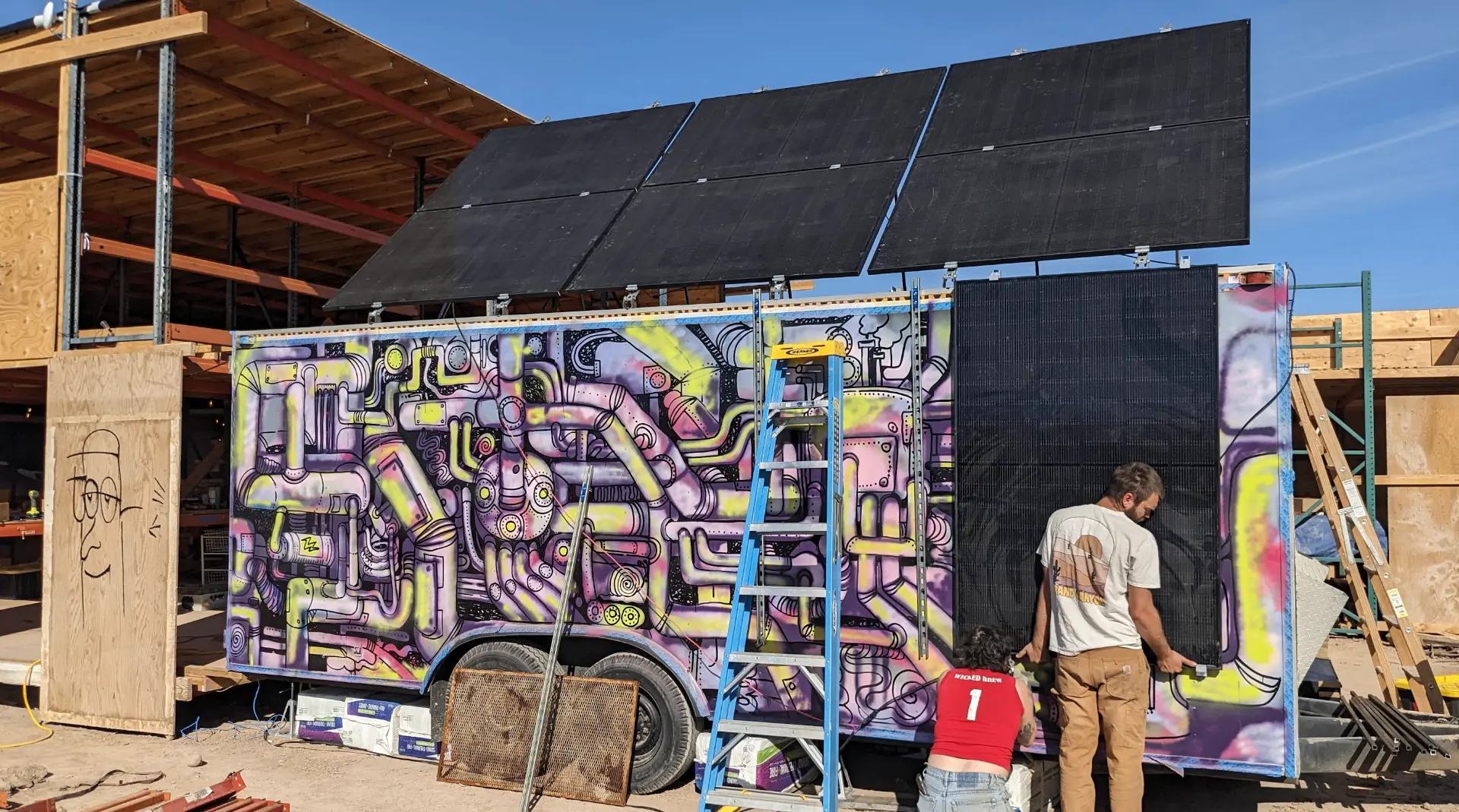 A mural of intertwined pipes and machinery painted across a solar-panel wall