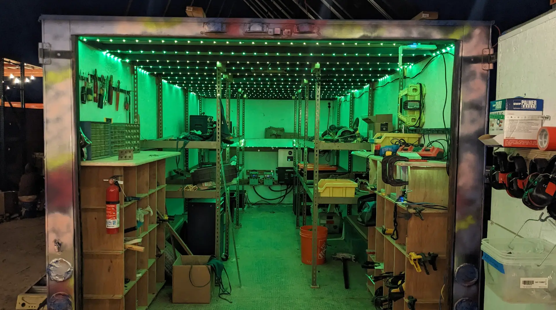 The tool-trailer interior at night, green LEDs above the tool shelves